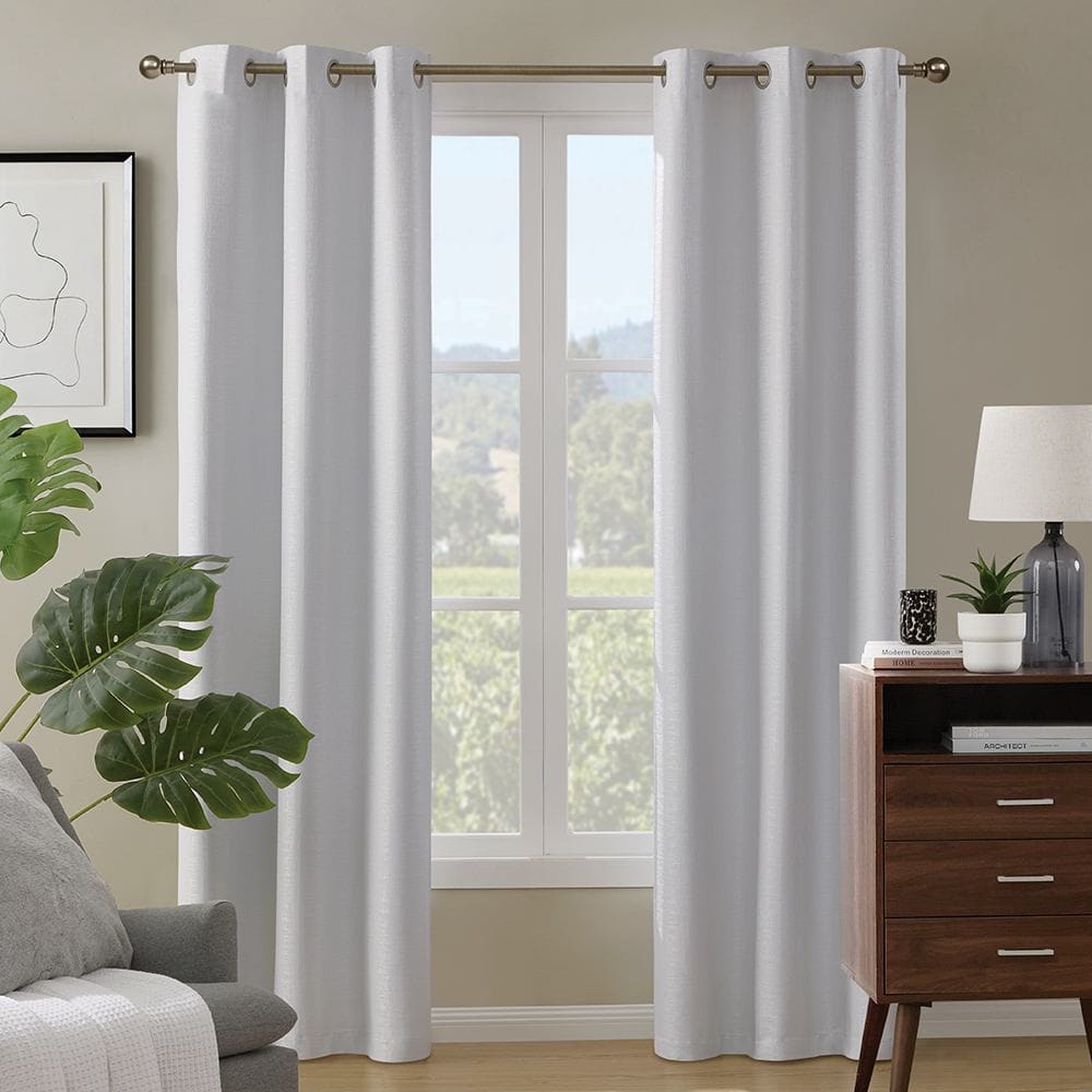 Paloma 100% blackout panels in white on grommets at a tall window